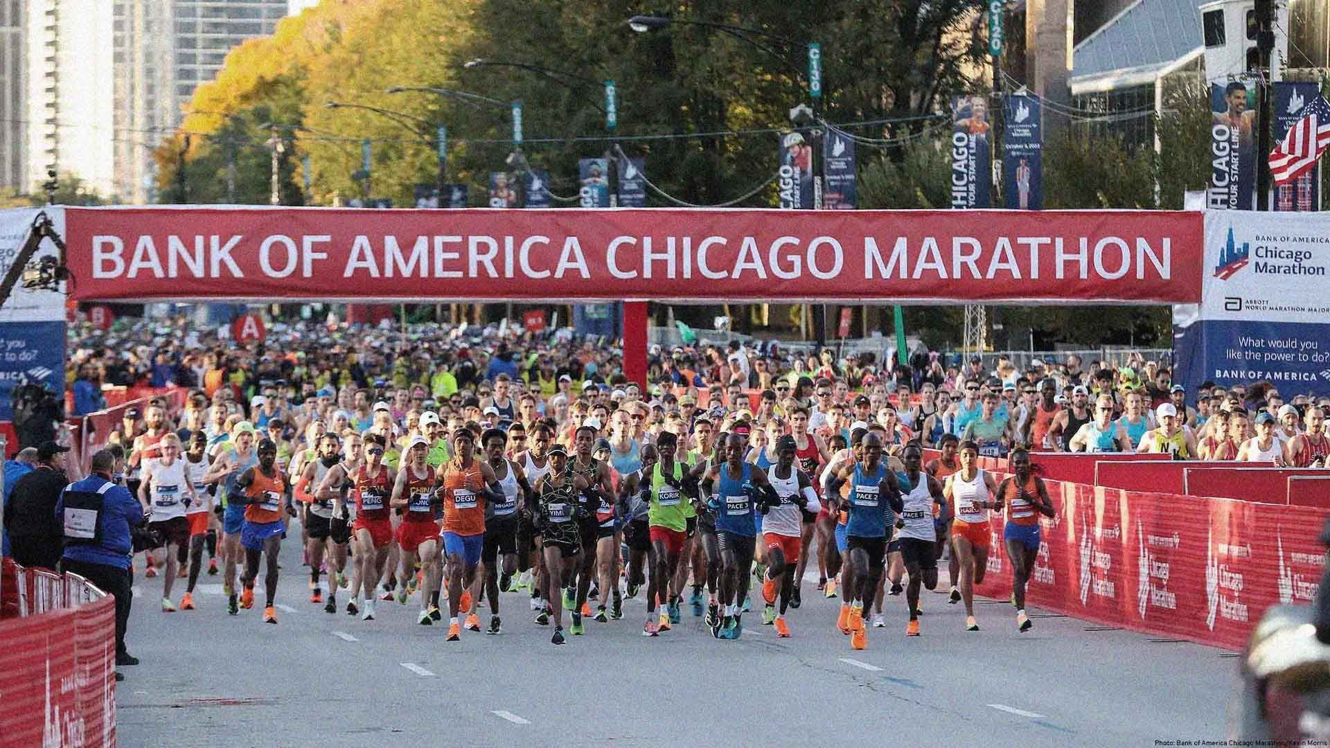Hundreds of runners taking off from the start line at the Chicago Marathon. A large sign reads "Bank Of America Chicago Marathon".